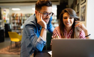 Laptopta birlikte çalışan mutlu gençler. Takım çalışması, öğrenim, teknoloji, iş ofisi konsepti