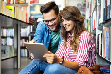 Mutlu genç üniversite öğrencileri birlikte okuyorlar. Üniversitede bir grup çok ırklı insan