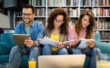 Öğrenci beyin fırtınası çalışıyor. Kütüphane arkadaşları takım çalışması kavramını analiz ediyor.