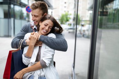 Alışveriş ve eğlence zamanı. Mutlu, başarılı, mutlu, alışveriş torbaları ve kahkahalarla dolu genç bir çift.