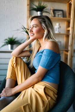 Evdeki güzel sarışın kadının rahatlatıcı portresi.