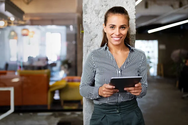 Ofisinde dijital tableti olan mutlu, kendine güvenen bir iş kadını portresi