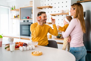 Mutfakta mutlu bir aile birlikte yemek pişiriyor. Evde sağlıklı yiyecekler..