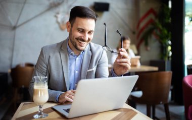 Kafede dizüstü bilgisayarın önünde oturan başarılı bir girişimcinin portresi..
