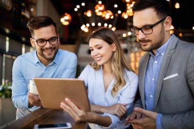 Genç iş adamları işyerinde eğleniyor ve sohbet ediyorlar.