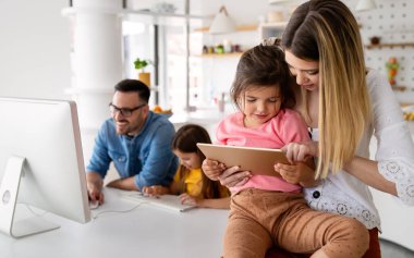 Tecrit ve çevrimiçi okul, teknoloji konsepti. Ebeveynler çocuklarına evde online ders çalışmaları için yardım ediyor.