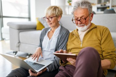 Mutlu yaşlı çift evde sarılıyor ve emekliliğin tadını çıkarıyor.