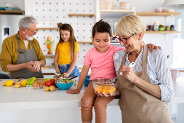 Mutlu büyükanne ve büyükbabalar evde torunlarıyla eğleniyor.