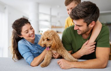 Mutlu bir aile portresi ve evde birlikte eğlenen bir köpek. Mutlu aile kavramı, hayvanları sevmek, çocukluk.