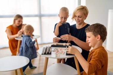 Çocuklar ve kadınlar, anneler masa oyunu oynarken öğrenirler. Eğitim, eğlence, çocuk konsepti