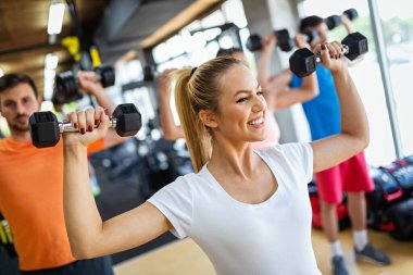 Spor salonunda egzersiz yapan bir grup fit genç. Sağlık, spor, arkadaş, mutluluk kavramı