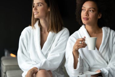 Güzel genç kadınlar spa merkezinde kahve içiyorlar.