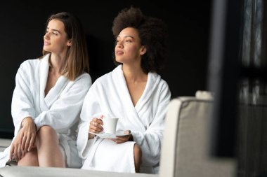 Güzel genç kadınlar spa merkezinde kahve içiyorlar.