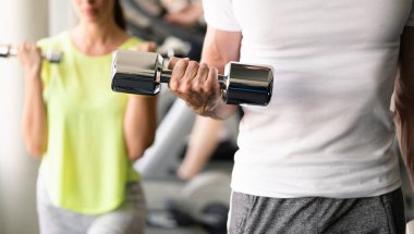 Spor salonunda birlikte antrenman yapan bir grup mutlu insan.