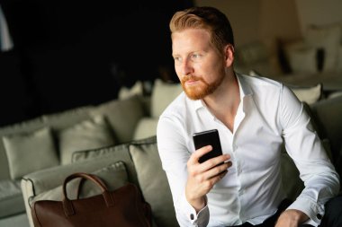 Akıllı telefon kullanan başarılı genç bir iş adamı.