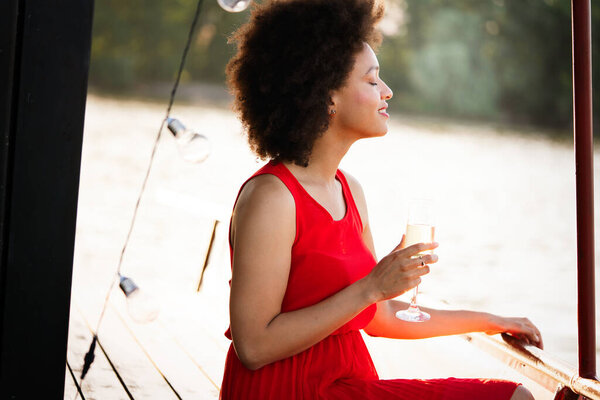 Summer lifestyle fashion portrait of young stylish black woman with drink