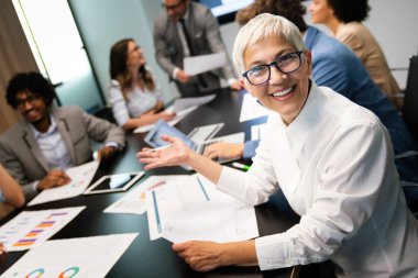 Bir grup girişimci ve işadamı modern toplantı odasında konferans veriyorlar.