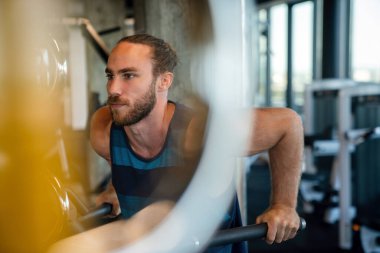 Yakışıklı vücut geliştirme uzmanı spor yapıyor ve spor yapıyor.