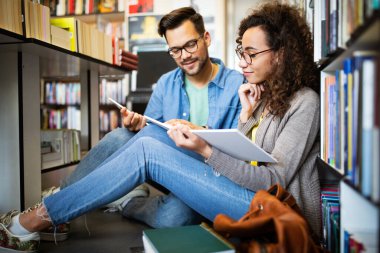 Okul kütüphanesinde okuyan bir grup üniversite öğrencisi. Eğitim, arkadaşlar, eğitim kavramı.