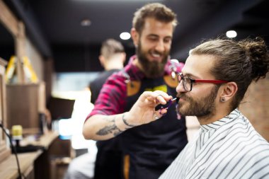 Berber dükkanında kuaförü ziyaret eden mutlu genç adam..