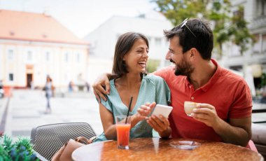 Mutlu çift kahve içiyor ve yaz tatilinde açık hava kafesinde eğleniyor.