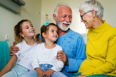 Mutlu aile hastane yatağında son sınıf erkek hastayı ziyaret ediyor. Sağlık, destek, aile kavramı