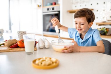 Mutlu güzel çocuk evde kahvaltı hazırlıyor.
