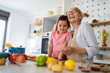 Aile eğlencesi aşk jenerasyonu konsepti. Büyükannem ve torunum mutfakta yemek pişiriyorlar..