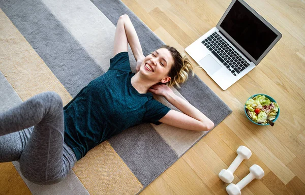 Fitness, sport home and diet concept. Happy fit young woman exercising at home