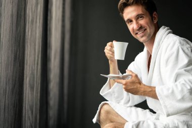 Bornozlu genç adam otelde kahve içiyor, spa merkezinde..