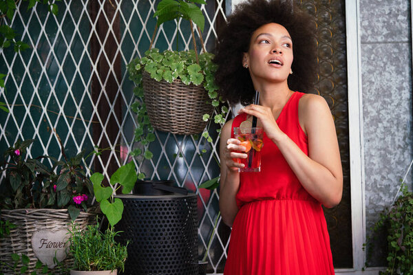 Fashion portrait of sexy pretty african woman with drink outdoor