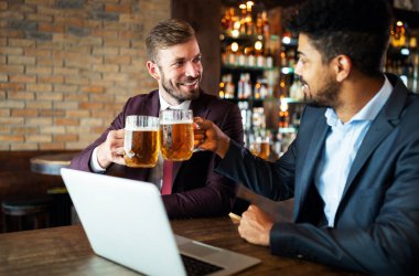 İş adamları işten sonra bira içer. İş adamları barda bira içmeyi sever.