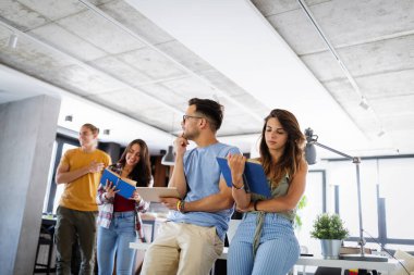 Grup çalışmasından hoşlanan bir grup genç. Projeleri için bilgi toplayan kitap ve dizüstü bilgisayarı olan mutlu üniversite öğrencileri.