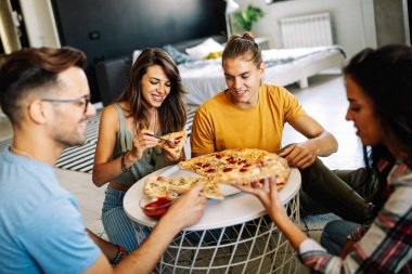 Bir grup mutlu arkadaş evde parti veriyor, pizza yiyor ve eğleniyorlar..