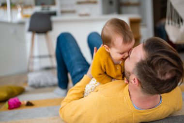 Baba ve kızı gülüyor ve kaynaşıyorlar. Babası ve küçük kızı evde vakit geçiriyorlar. Bekar baba eğlence aile hayatı kavramını sever.