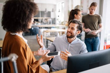 Genç iş ortakları ofiste görüşlerini ve planlarını paylaşıyorlar.