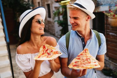 Tatildeyken pizza yiyen mutlu arkadaş grubu.