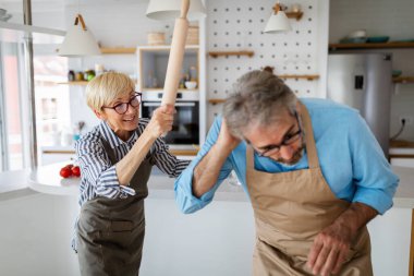 Aile kavgası. Üzgün, korkmuş yaşlı adam evde sinirli olgun bir kadına karşı.