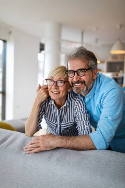 Mutlu, olgun bir çift evde birbirine sarılıyor ve gerçek duygularla kaynaşıyor.