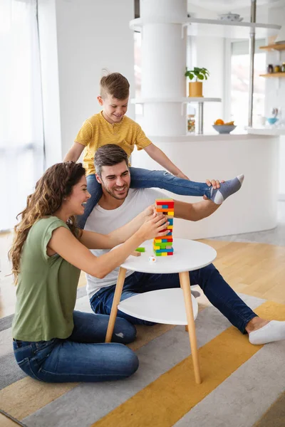 両親と息子と幸せな家族は家でカラフルなブロックで遊んでいます — ストック写真