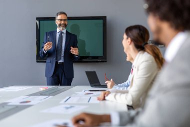 Çeşitli iş arkadaşları modern ofiste iş projesinde birlikte çalışıyorlar.