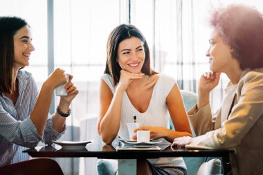 Bir grup iş kadını kafede sohbet edip kahve içmekten zevk alıyorlardı.