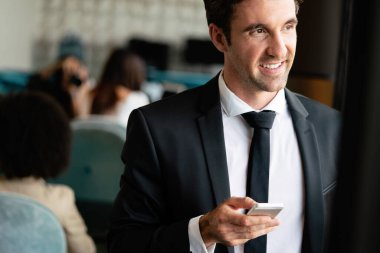 Ofiste cep telefonu kullanan başarılı bir iş adamı. İş, teknoloji, insan kavramı