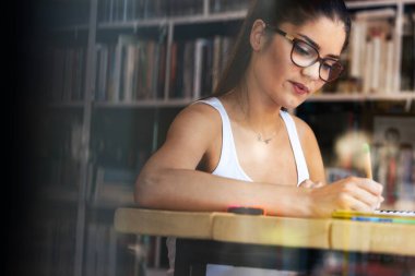 Masada otururken çalışan güzel bir kızın portresi.