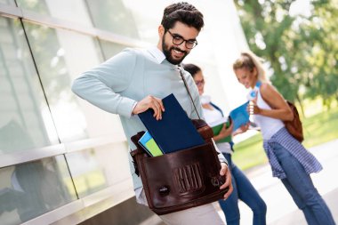 Kitapları olan mutlu üniversite arkadaşları ders çalışırken eğleniyorlar. Arkadaşlık, eğitim, eğitim kavramları.