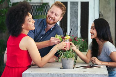 Bir grup arkadaş birlikte eğleniyor. Kadınlar ve erkekler gülüyor ve eğleniyorlar.