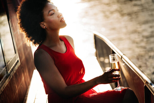 Summer lifestyle fashion portrait of young stylish black woman with drink