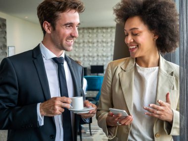 Kahve molası sırasında sohbet eden genç, mutlu profesyoneller.