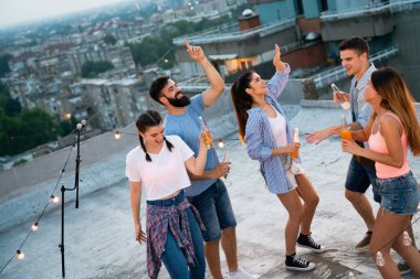 Genç arkadaşlarımla harika vakit geçiriyorum, çatı partisinde eğleniyorum.