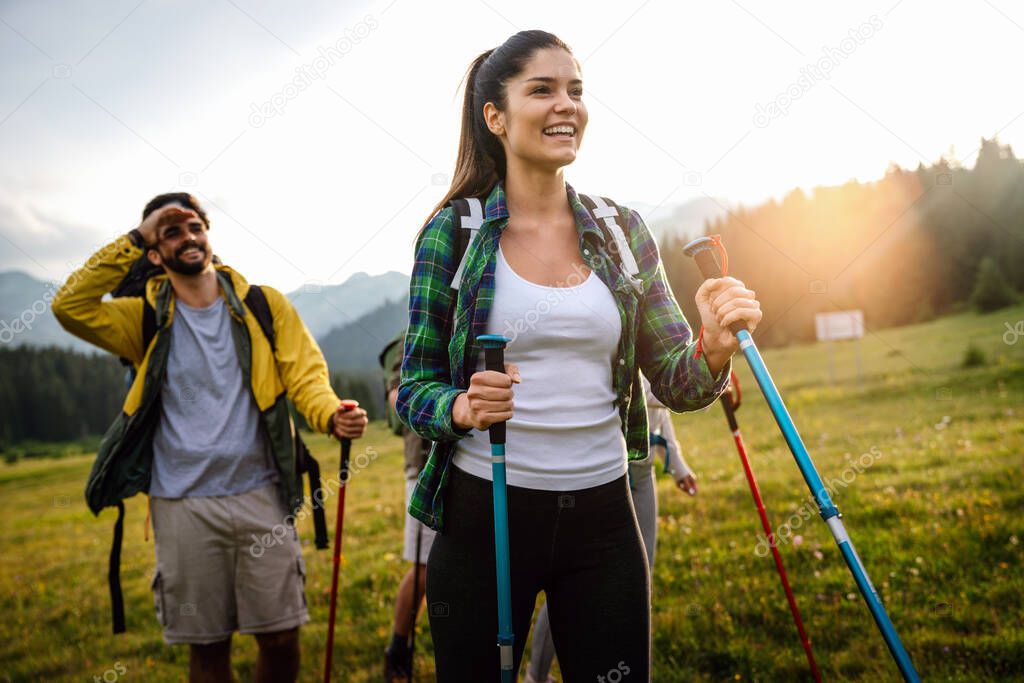 Group of friends trekking with backpacks walking outdoor